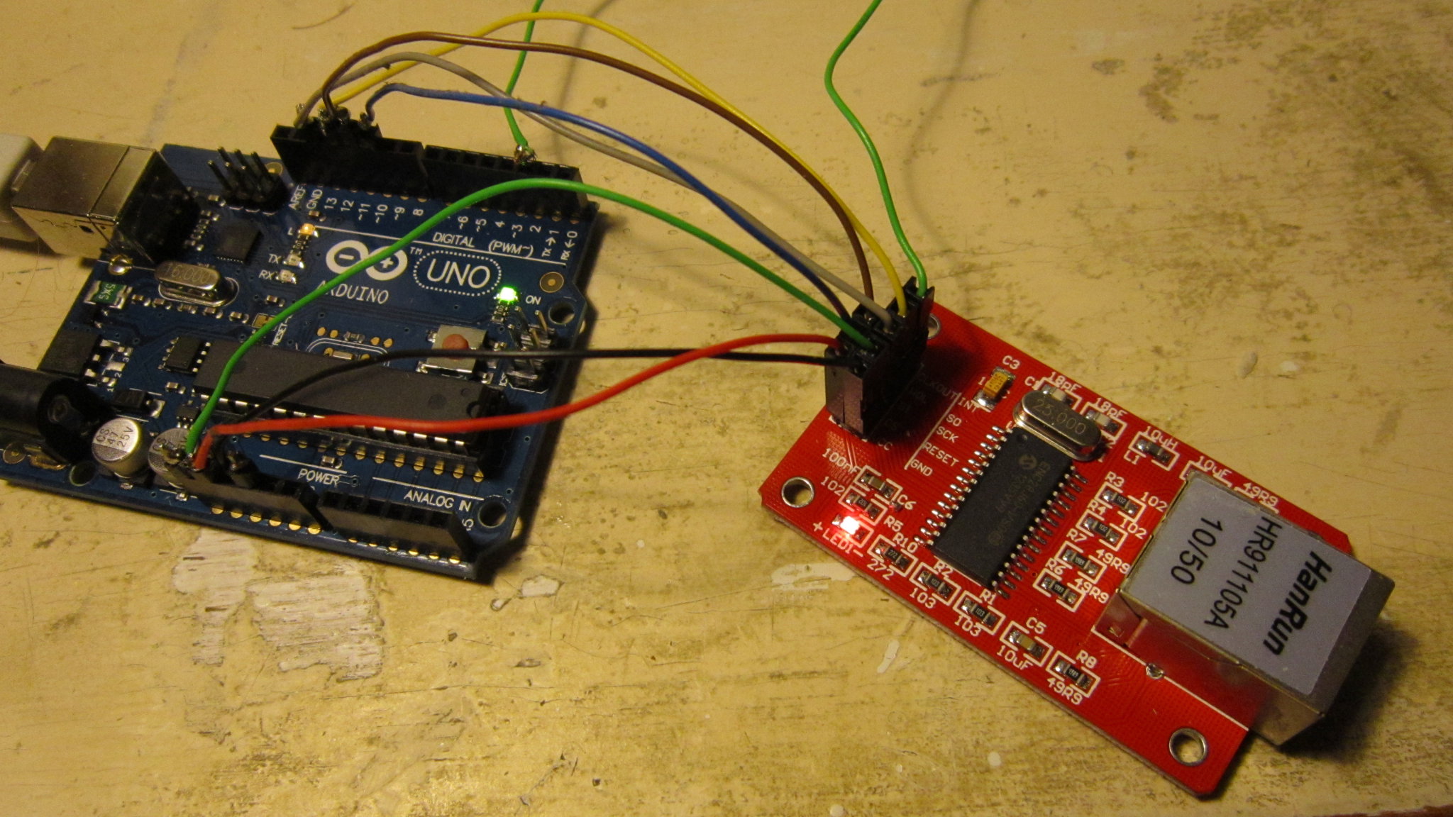 ENC28J60 ethernet module connected to an arduino.The markers onthe PCB may be a tad confusing. Vcc is the leftmost connection at the closest end. (red),